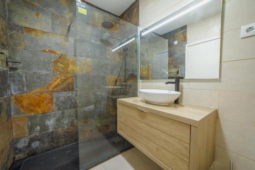 een badkamer met een wastafel en een douche bij Pateo In Lapa City Center by Vacationy in Porto