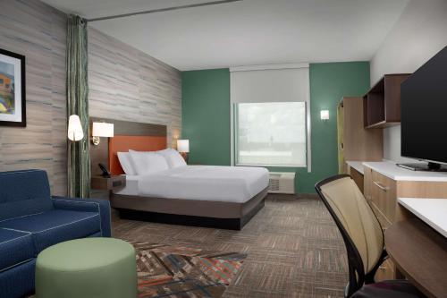 Home2 Suites By Hilton Cullman في كولمان: غرفة فندق بسرير وتلفزيون