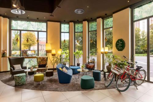 een lobby met fietsen in een kamer met ramen bij Vienna House Easy by Wyndham Leipzig in Leipzig