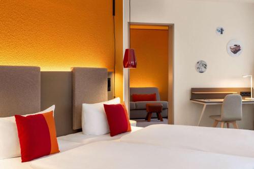 a hotel room with a bed and a desk at Vienna House Easy by Wyndham Leipzig in Leipzig