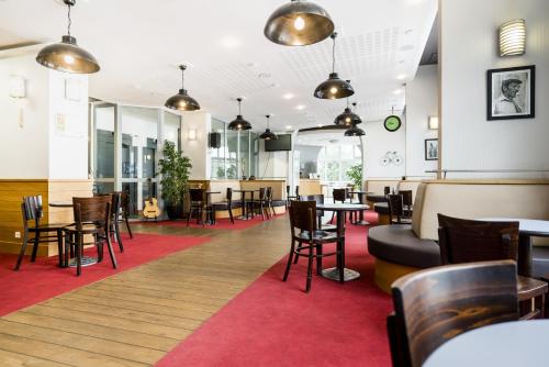 un restaurante con mesas y sillas y una alfombra roja en Villages Clubs du Soleil - LA BAULE, en La Baule