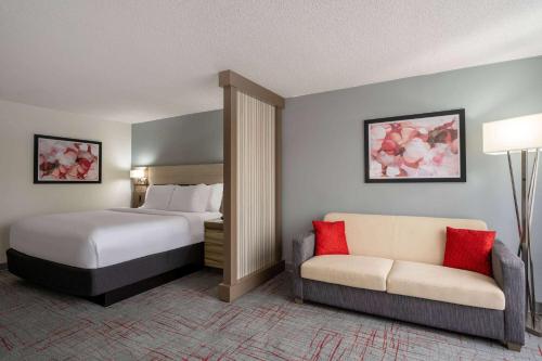 a hotel room with a bed and a couch at Wyndham Garden Columbia-Ft Jackson in Columbia