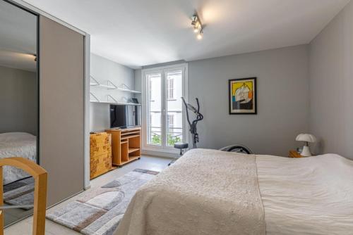 une chambre avec un grand lit et une télévision dans l'établissement Serbes Croisette - 100m Beach, Palais, Parking/AC, à Cannes