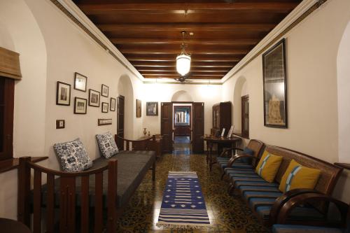 a living room with couches and chairs and a hallway at The Mundanad House in Trivandrum