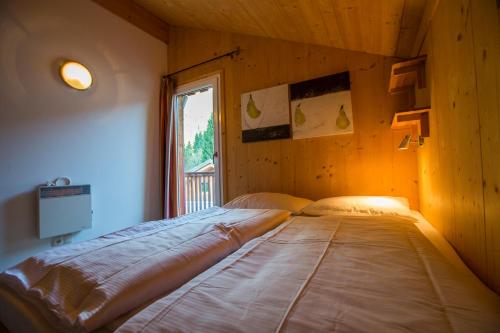 a bedroom with two beds in a room with a window at Alpendorf Dachstein West by ALPS RESORTS in Annaberg im Lammertal