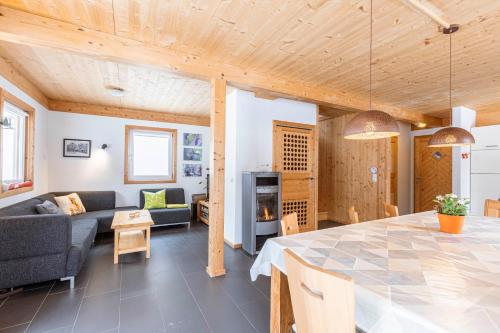 a living room and dining room with a table and a couch at Alpendorf Dachstein West by ALPS RESORTS in Annaberg im Lammertal