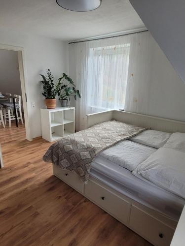 Schlafzimmer mit einem Bett, einem Fenster und einem Tisch in der Unterkunft Apartment Ferienwohnung Steigwaldweg in Würzburg