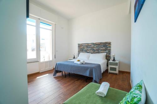 a bedroom with a bed and a large window at CapoSud - Suite Randa in Marina di Ragusa