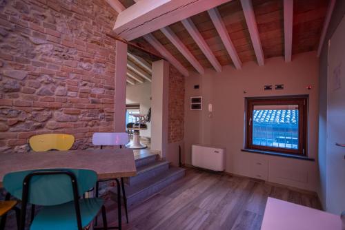 a room with a table and chairs and a brick wall at Agriturismo La Ratta in Vernasca