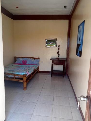 a bedroom with a bed and a table at Malapascua Be One Guesthouse in Malapascua Island