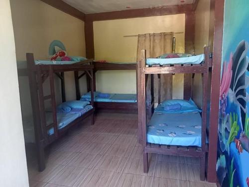 a room with three bunk beds in it at Malapascua Be One Guesthouse in Malapascua Island