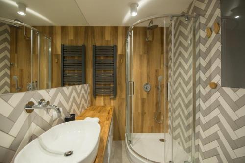 La salle de bains est pourvue d'une baignoire, d'un lavabo et d'une douche. dans l'établissement VacationClub – Bukowa 17A Apartament E.2, à Wisła