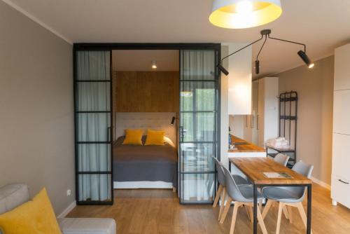 a bedroom with a bed and a table and chairs at VacationClub – Bukowa 17A Apartament E.2 in Wisła
