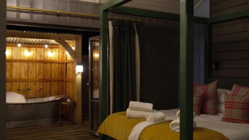 a bedroom with a tub and a bed and a bath room at Retreat East in Ipswich