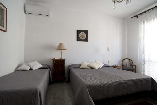 ミステルビアンコにあるRelais Chiesa Madre - Rooms and Apartmentsのベッドルーム1室(ベッド2台、壁掛け時計付)