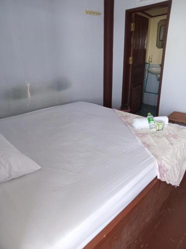 1 cama blanca grande en una habitación con espejo en Sunset bar bungalows, en Muang Không
