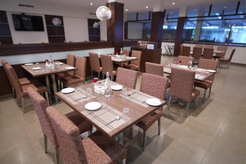 a dining room with wooden tables and chairs at Greenleaf The Resort & Spa, Ganpatipule in Ganpatipule