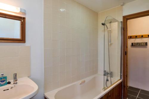 a bathroom with a tub and a sink and a shower at Finest Retreats - Swallows at St Keverne in Saint Keverne