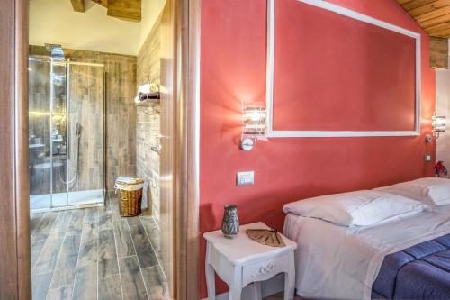 ソレントにあるAmore Rentals - Appartamento Carusoの赤い壁のベッドルーム1室、ベッド1台、シャワーが備わります。