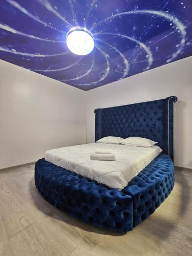 a bedroom with a blue bed with a star ceiling at Blue Apartament Braila in Brăila