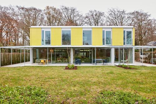 een geel huis met een gazon ervoor bij EvaMaria in Varsenare