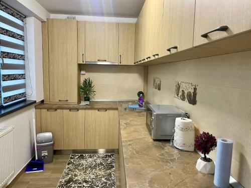 a large kitchen with wooden cabinets and a sink at D&D New Residence in Piteşti