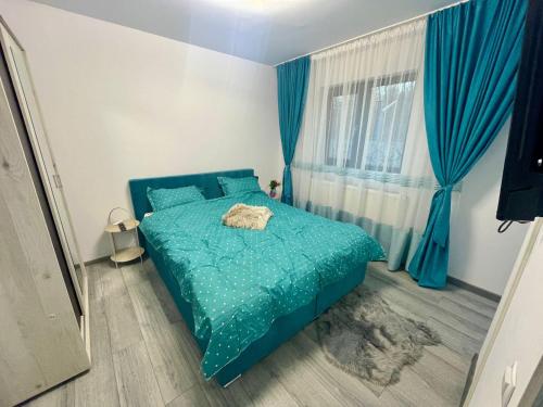- une chambre avec un lit bleu et des rideaux bleus dans l'établissement D&D New Residence, à Piteşti