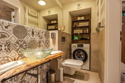 a bathroom with a sink and a washing machine at Historical Wine Apartment in Bratislava