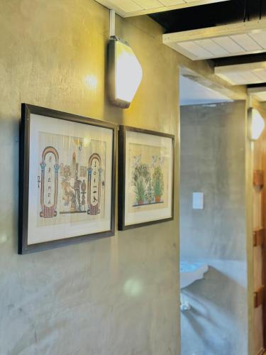 três quadros pendurados numa parede em The Continental Hostel El Nido em El Nido
