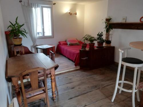a small room with a red bed and a table at Studio cosy in Uzerche