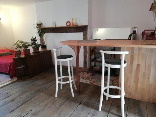 Studio cosy في مدينة أوزيرش: طاولة خشبية مع ثلاثة كراسي في الغرفة