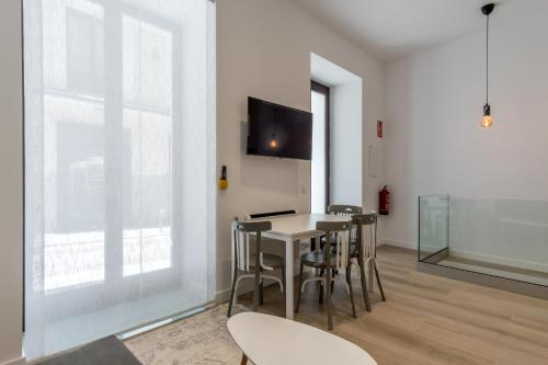 uma sala de jantar com mesa e cadeiras e uma televisão em Modern and Bright- 2 Bd 2 Bth - Center em Madri