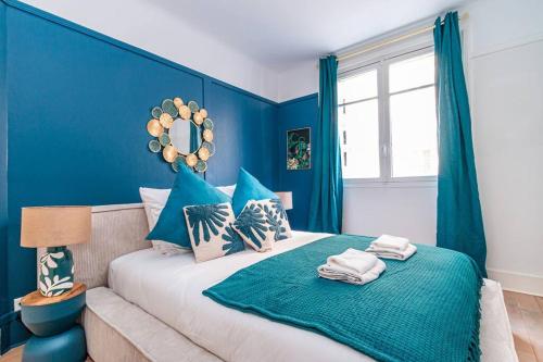- une chambre bleue avec un grand lit aux murs bleus dans l'établissement Charmant Appartement au Cœur de Neuilly-sur-Seine, à Neuilly-sur-Seine