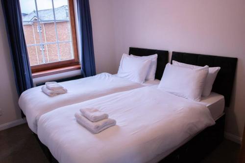 Dos camas en una habitación con toallas. en My Waterfront Apartment, views over Water of Leith, en Edimburgo