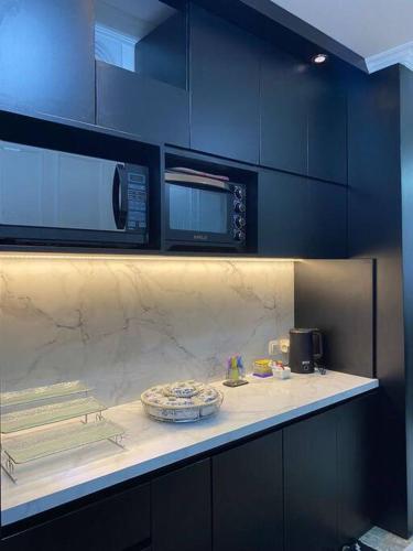 eine Küche mit einer Arbeitsplatte mit Mikrowelle in der Unterkunft Rumahtata Homestay in Purwokerto