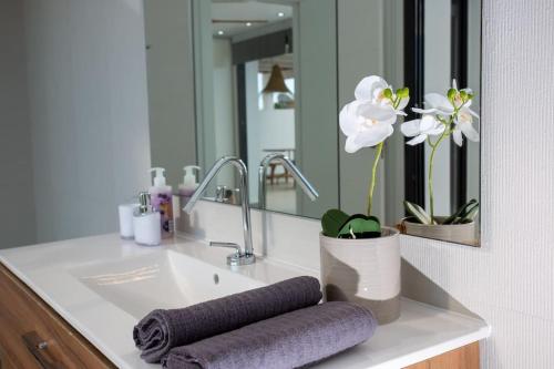 Casa Sãnti - Luxury Home- For 8 guests في بينيسا: حوض الحمام والمناشف والمرآة