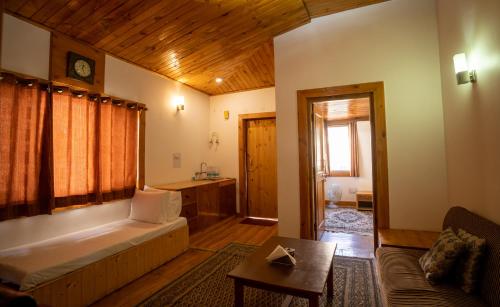 uma sala de estar com uma banheira e uma mesa num quarto em THE CONIFER em Manali