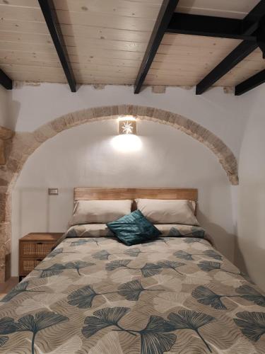 ein Schlafzimmer mit einem großen Bett und einer Holzdecke in der Unterkunft Archi Antichi in Putignano