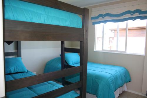Pokój z łóżkiem piętrowym z 2 łóżkami piętrowymi i oknem w obiekcie Casa Pucon w mieście Pucón