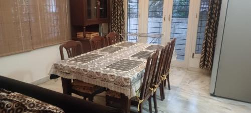 uma mesa de jantar com cadeiras e uma toalha de mesa em Hudson New York Amazing villa 1 em Bangalore