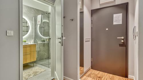 a bathroom with a shower and a glass door at Rezydencja Niechorze 125 z ogródkiem i przy plaży - 5D Apartamenty in Niechorze