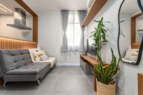 een woonkamer met een bank en een plant bij Arpoador Design - Quadra da Praia e WIFI 500Mb in Rio de Janeiro