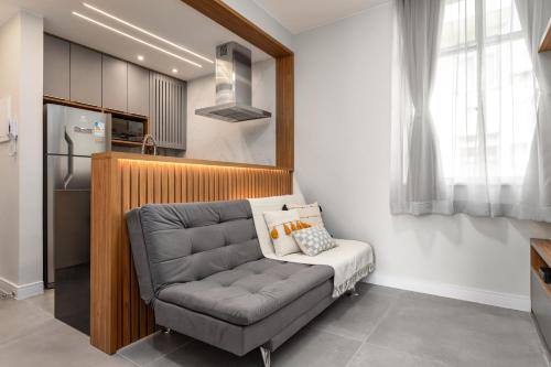 een woonkamer met een bank en een keuken bij Arpoador Design - Quadra da Praia e WIFI 500Mb in Rio de Janeiro