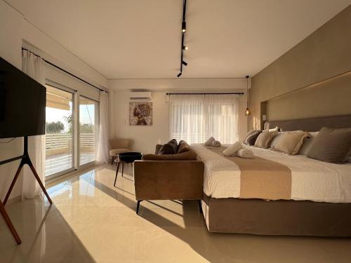 a bedroom with a large bed and a couch at VoulaCnSand in Athens