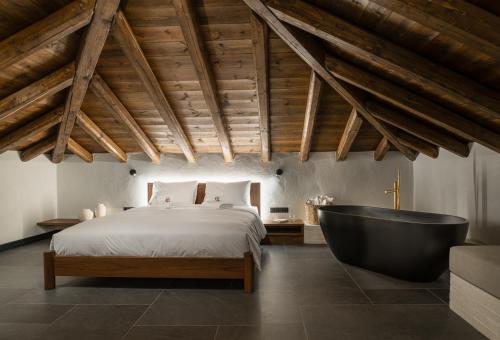a bedroom with a bed and a bath tub at Unedo All Seasons Boutique Hotel in Palaios Panteleimon