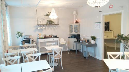 a restaurant with white tables and chairs and a counter at Hotel Charlotte / Stella in Uppsala