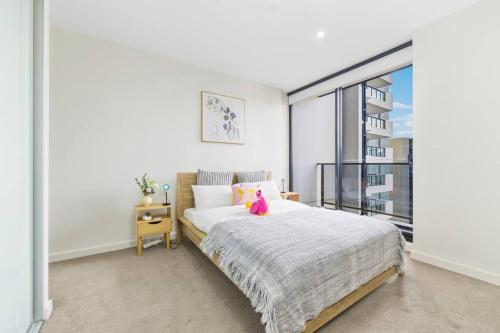 a bedroom with a bed with a pink stuffed animal on it at Stylish apartment in Parramatta in Sydney