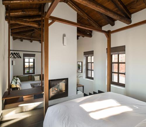 a bedroom with a bed and a fireplace at Unedo All Seasons Boutique Hotel in Palaios Panteleimon