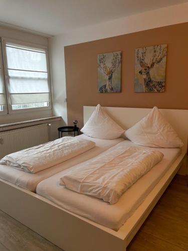 Ferienwohnung Schaaf في ليمبورغ ان دير لان: سرير أبيض كبير في غرفة نوم مع نافذة
