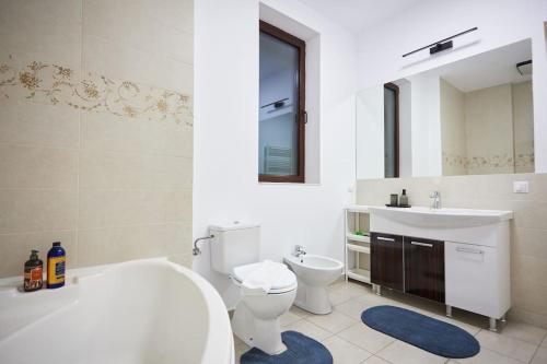 a bathroom with a tub and a toilet and a sink at Caragiale Apartment in Bucharest